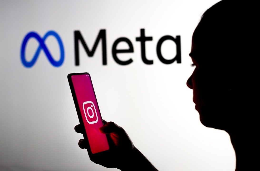 March 16, 2022, Brazil. In this photo illustration, a woman holds a smartphone with the Instagram logo displayed on the screen with the Meta Platforms logo displayed in the background.